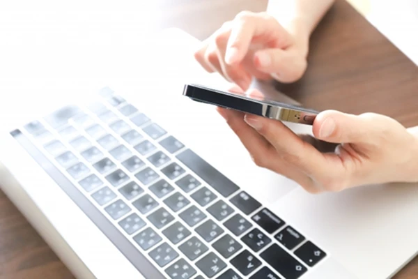 スマートフォンにてお問い合わせをする人の手元